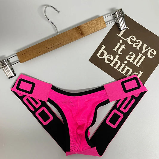 Pink strap underwear laying flat off a hanger with a sign that says leave it all behind