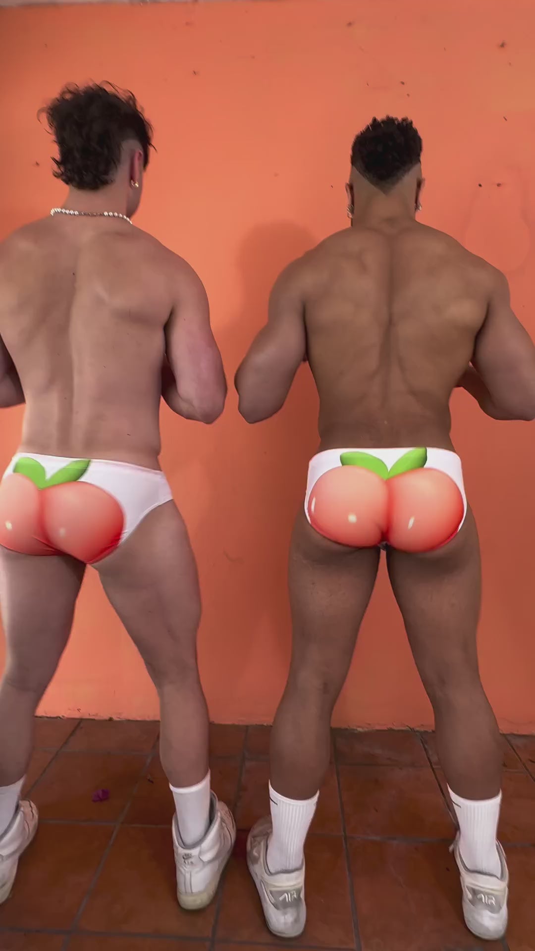 video of 2 guys showing off their peach swimwear and laughing